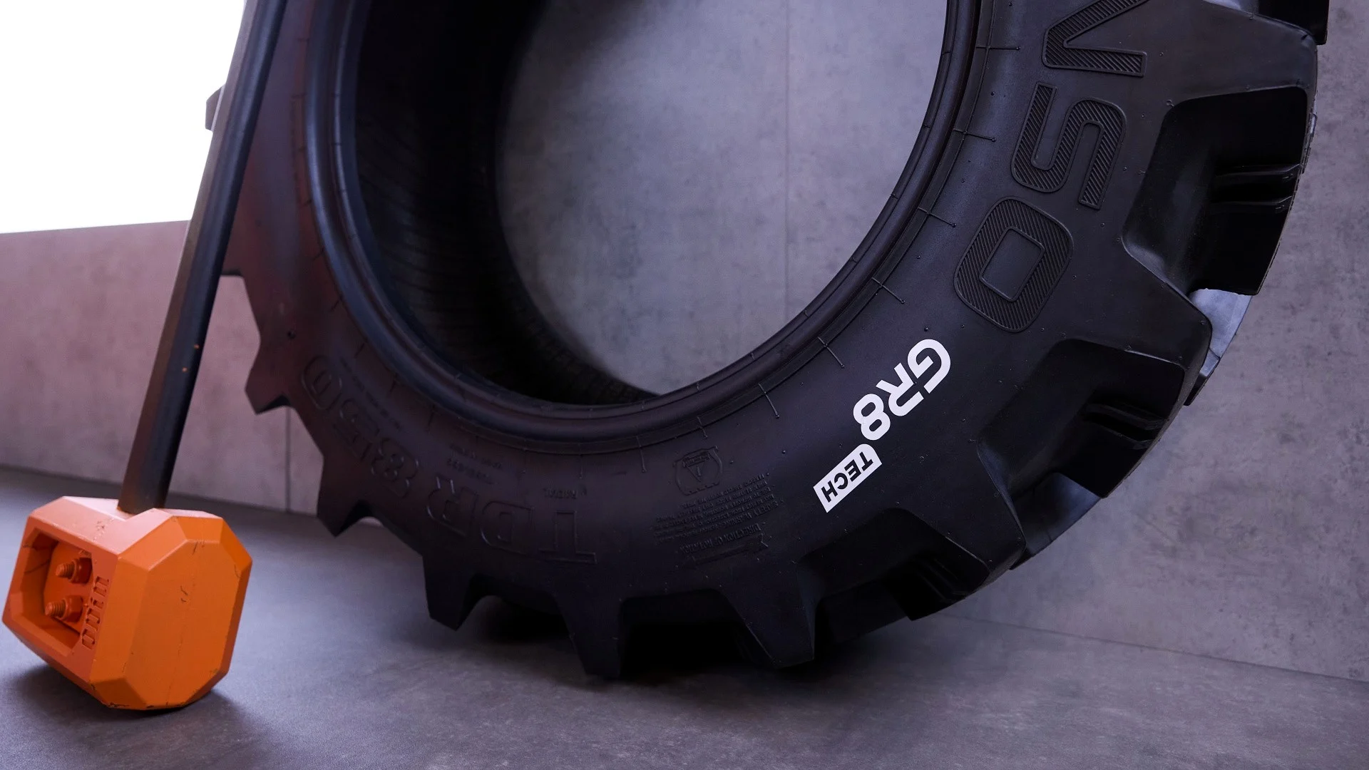 A GR8 Tech branded tyre with a hammer featuring GR8 Tech's brand colour
